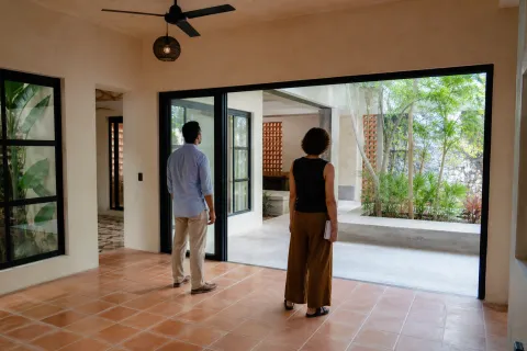 Personas recorriendo con atención el interior y patio de una vivienda